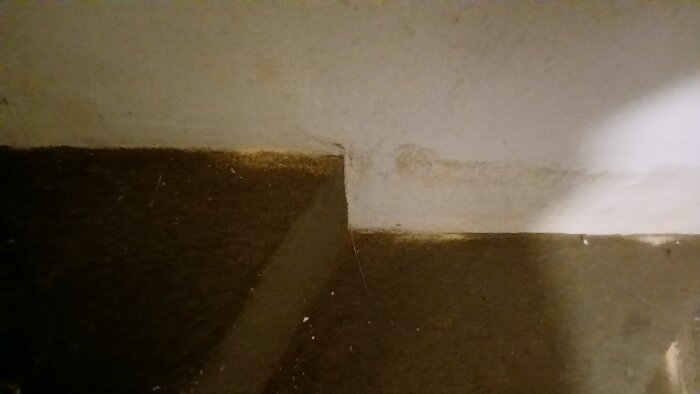 Hål i träplanken med sågspånsrester, i ett gammalt trähus, möjligen orsakat av insekter.