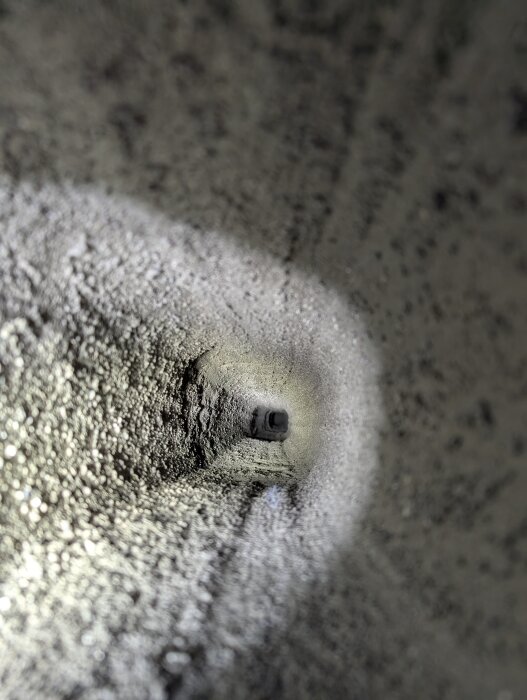 Insidan av en rensad skorsten med ren puts och beläggning efter en takrenovering.