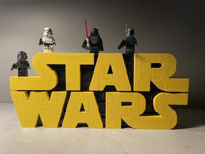 Legofigurer från Star Wars placerade på en stor gul Lego-text som formar orden "STAR WARS".