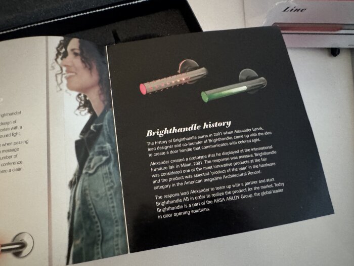 Folder med historik om Brighthandle och två bilder på dörrhandtag med färgad belysning.