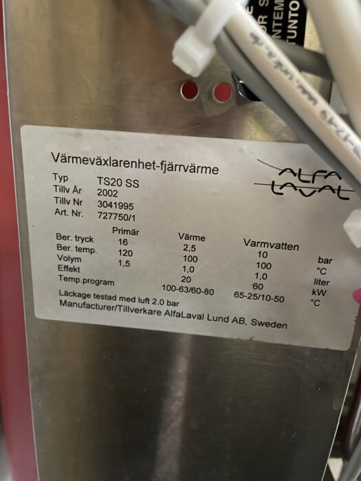 Närbild av värmeväxlarenhet från Alfa Laval, skylt visar specifikationer som typ TS20 SS och tillv. år 2002.
