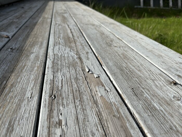 Träaltan med stora sprickor och flagnande blåaktig ytbehandling.