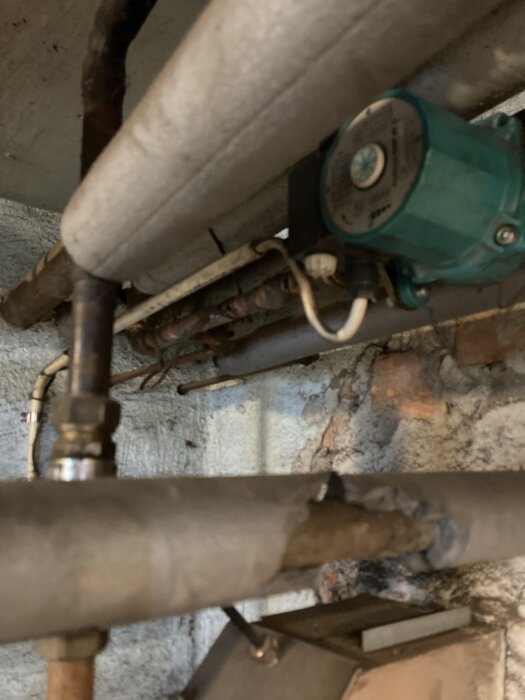 Vattenrör och pump i källare, givare synlig efter pumpen.