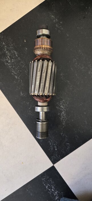 Rotor från en Cylinda FT46 tvättmaskin med synliga SKF lager, placerad på ett svartvitt rutmönstrat golv.