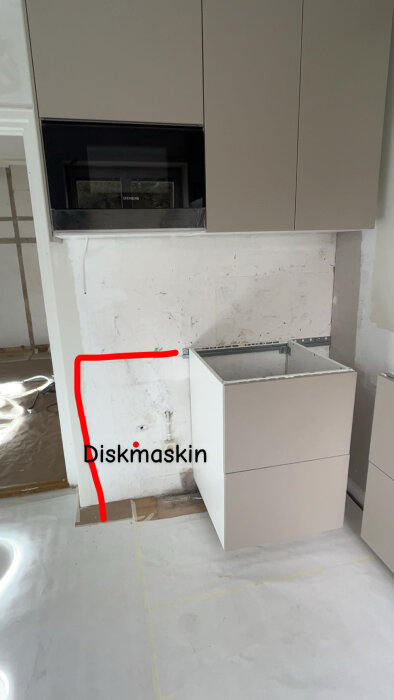 Kök med en oinstallerad stenbänkskiva, tom diskho och diskmaskin markerad med röd linje till höger.