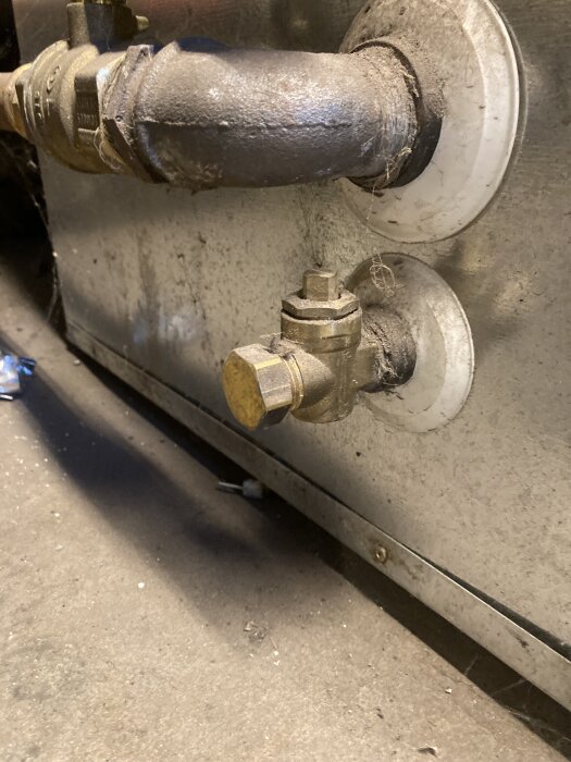 Ventil eller kran monterad på en tank, del av rörsystem.