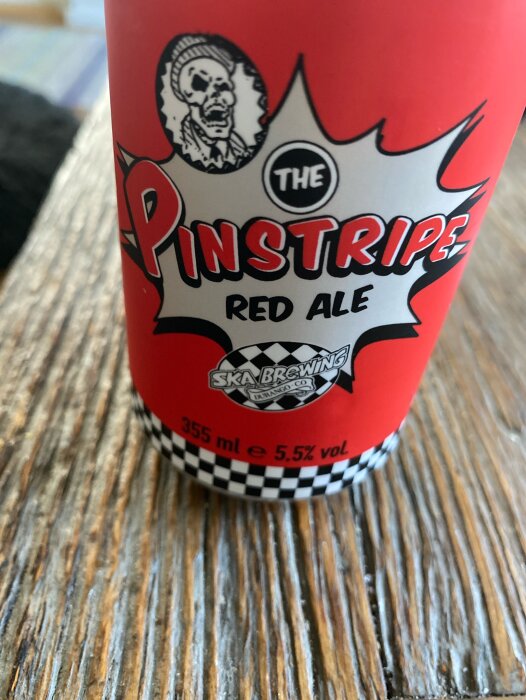 Röd ölburk med texten "The Pinstripe Red Ale" från Ska Brewing, 355 ml, 5,5% vol.