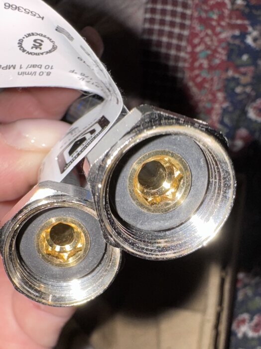 Två metalliska krananslutningar för utomhusbruk visas i närbild, med etikett bifogad.