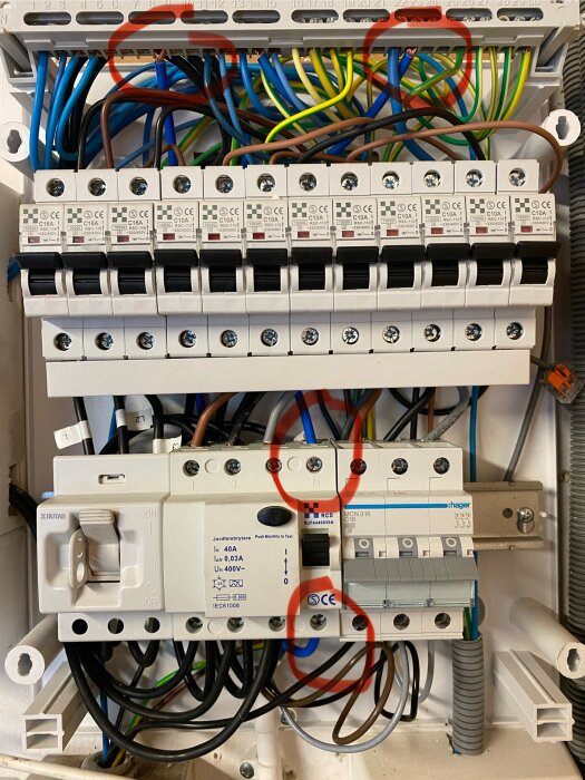 Elcentral med flera automatsäkringar och jordfelsbrytare, kablar dragna till nollskenan före och efter JFB, markerade i rött.