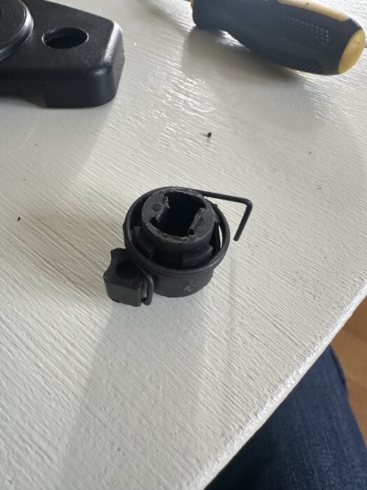 Fjädersystem på ett bord med en skruvmejsel i bakgrunden, illustrerar montering på en Klippo Excellent SH gräsklippare.