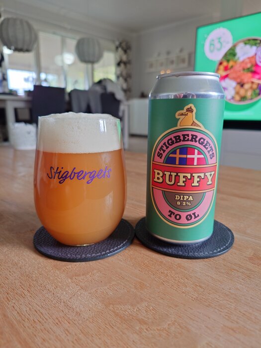 En ölburk med etiketten "Stigbergets Buffy DIPA" och ett glas fyllt med samma öl på ett bord.