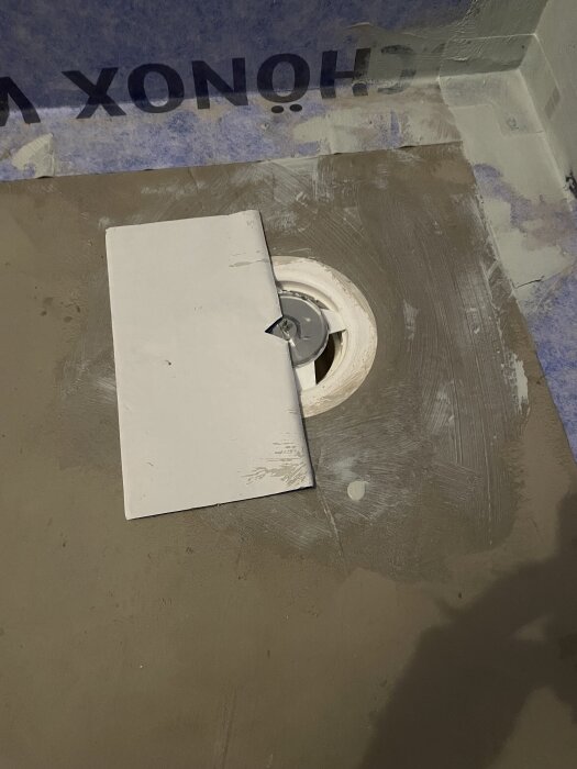 Platta med urtag placerad över brunn i ett pågående byggprojekt.