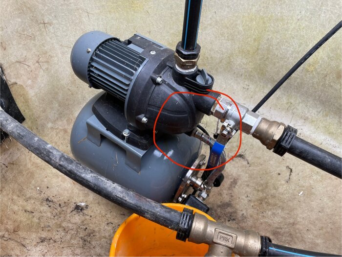 Hydrophore pump från Meec Tools som läcker, med inringat område där vatten sipprar ut. Anslutna rör och ventiler synliga runtomkring.