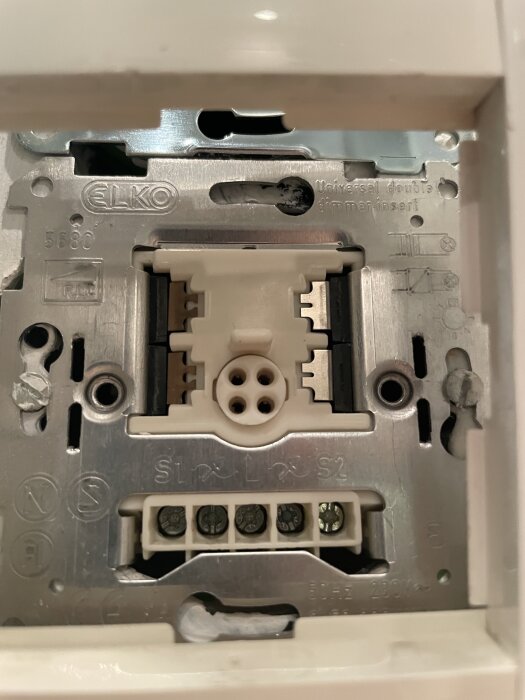ELKO strömbrytare modell 5680 med dimmerfunktion, monterad i vägg. Elektriska anslutningar synliga, del av serie om fyra på höjden.