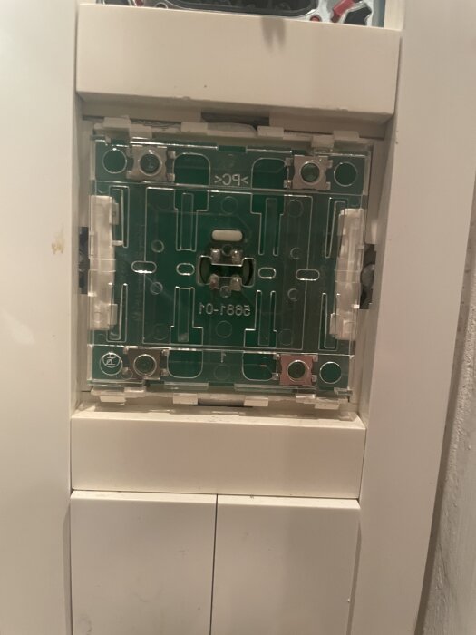 Närbild av en demonterad strömbrytare av märket ELKO, med inblick i det inre kopplingsskiktet.