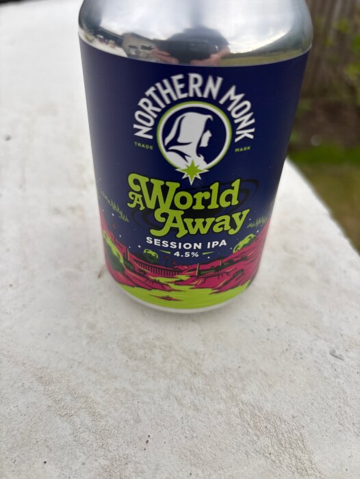 En burk Northern Monk A World Away Session IPA 4.5% på ett vitt underlag.
