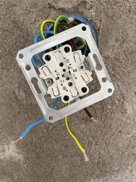 Elektrisk kopplingsbox på vägg med flera synliga ledningar i olika färger förbereda för installation.