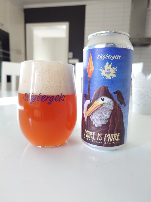 Ett glas och en burk Stigbergets More is More West Coast IPA på ett bord i ett kök.