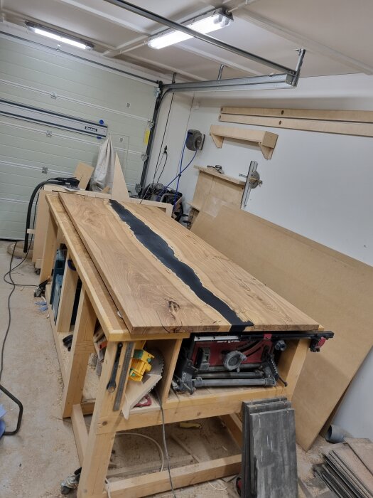 Epoxibord på arbetsbänk i verkstad med pågående ytskiktsbehandling och verktyg runtom.