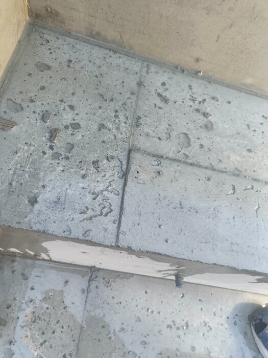 Betongstruktur med synliga gropar och ytor i behov av slipning, insida av en gjuten betongbalja med bänkar på tre sidor.