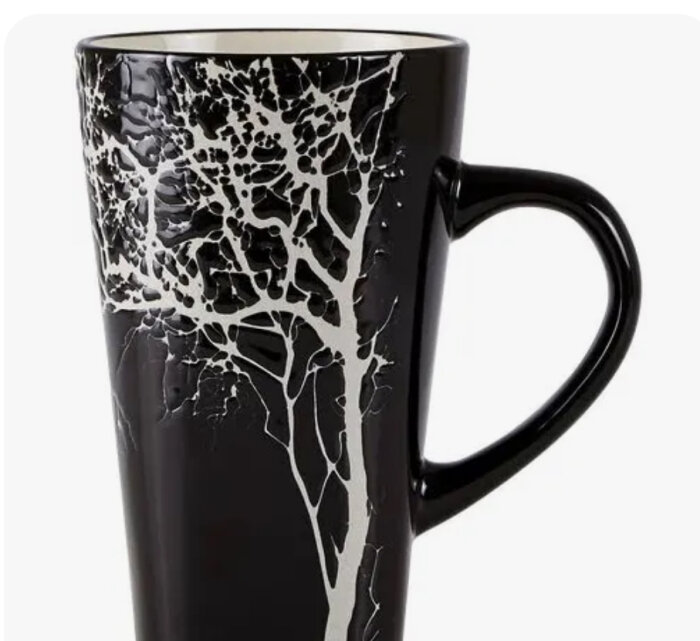 Svart mugg med ett vitt trädtryck som sträcker sig över utsidan.