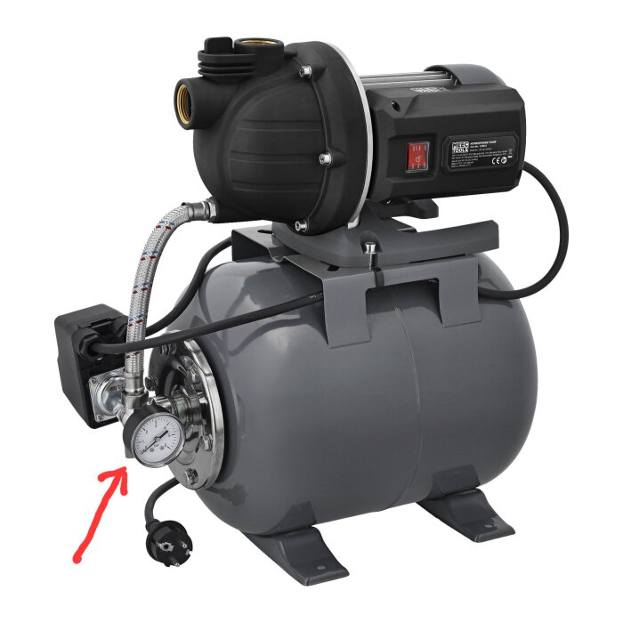 Vattenpump med manometer och markerad tömningsplugg, pil visar lägsta punkten på installationen.