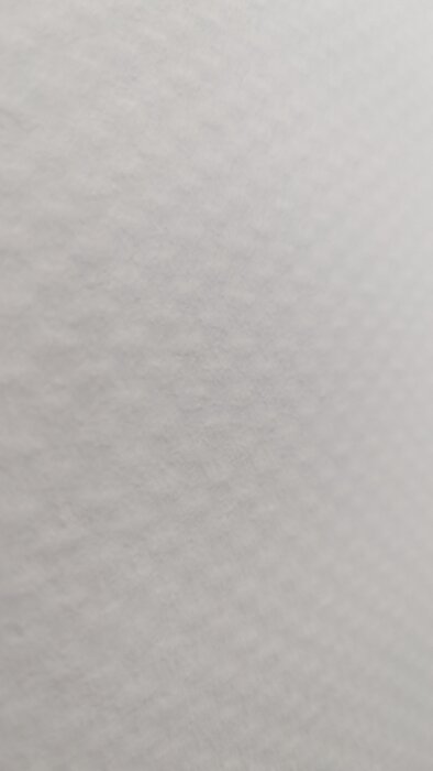 Närbild av vit strukturtapet med diskret mönster och textur.