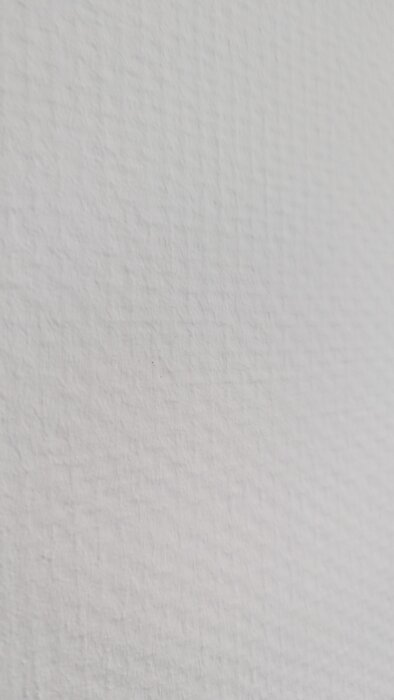 Närbild av en vit strukturtapet med rutmönster.