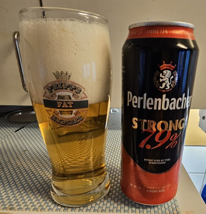 Ölglas med Pripps-logotyp bredvid en burk Perlenbacher Strong öl, 7,9% alkoholhalt.