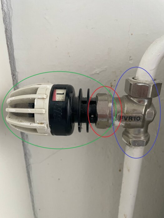 Termostat på vattenburet element i kök med gröna, röda och blå cirklar som markerar byten och ventiler.