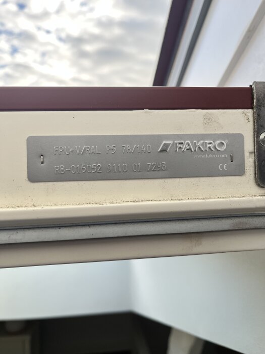 Närbild på en etikett inuti en takfönsterram med texten "FAKRO" och tekniska specifikationer.