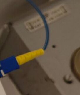 Fiberkontakt med blå och gul kabel i samband med diskussion om överföringsfel på grund av känslighet för böjning av fiberkablar.