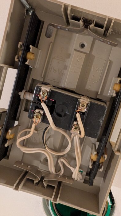 Öppen ringklocka med flera kablar kopplade till terminaler, visar komplex inkoppling för elschema.