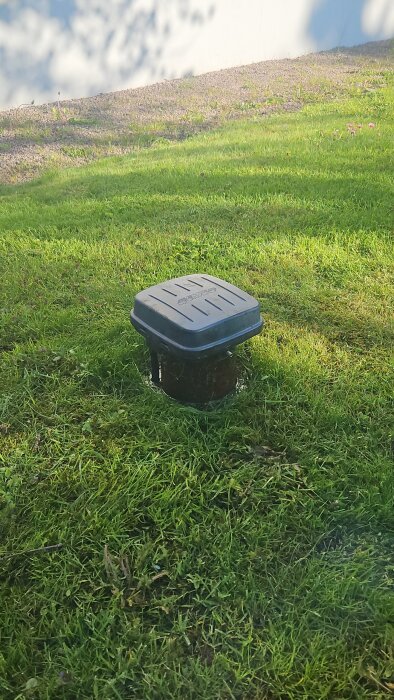 Rör med lock i gräsmatta, möjligen till en djupborrad brunn, vattenläckage upptäckt av ny husägare.