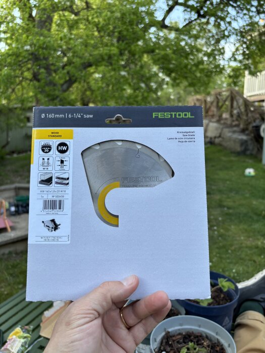 Förpackning med en Festool sågklinga, 160 mm, visas upp utomhus.