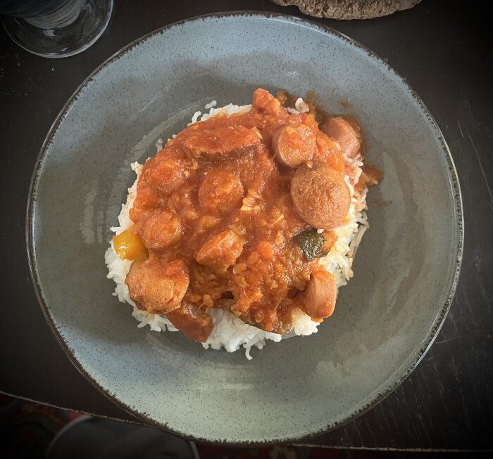 Korvgryta med ris serverad på en tallrik.