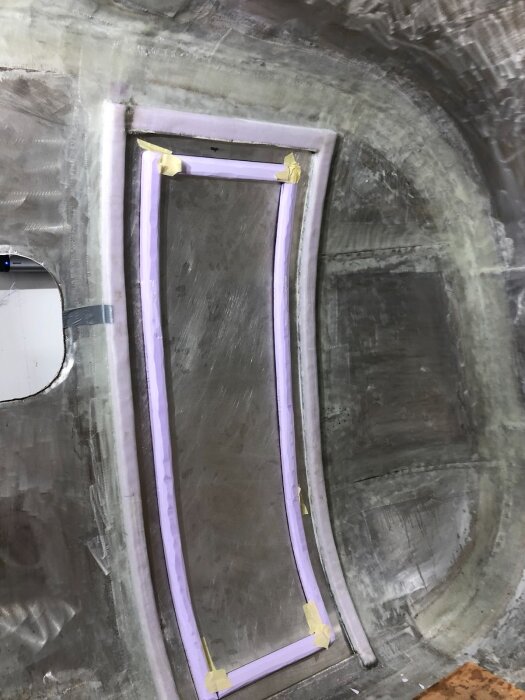 Inplastning av dörrstomme med metallplåt och XPS-balkar inomhus, fastsatt med tejp för att bibehålla rätt form.