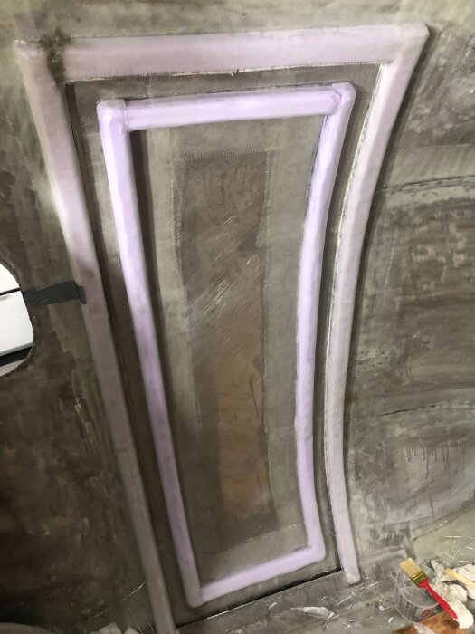 Blivande dörrstomme med insydda XPS-balkar och epoxyplastning, sedd inifrån under pågående renoveringsprojekt.