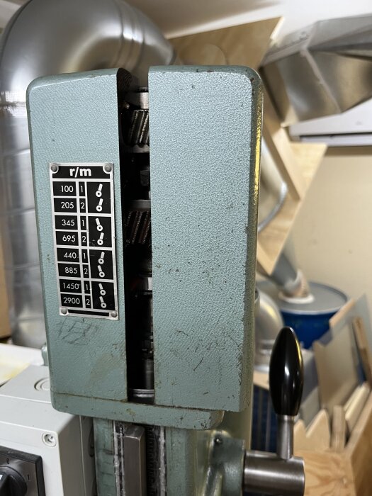 Öppen växellåda på en G2508-maskin visar kugghjul och en tabell med varvtal på sidan.