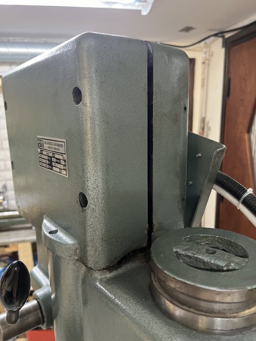 Delvis öppnad växellåda på en G2508-maskin med synliga skruvhål och svårigheter att öppna locket helt.