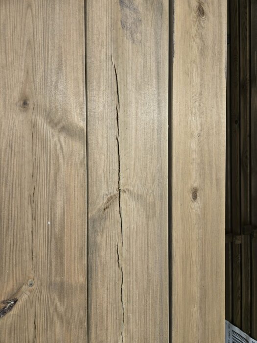 Brädor med en lång spricka, tänkta för altanbygge. Fråga om kvalitetsfråga på omfattande spricka i premium virke.