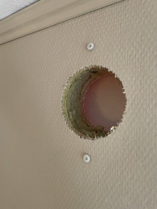 Öppen cirkulär håltagning i vägg för ventilation med synlig isolering; ska överluftsdon installeras korrekt?