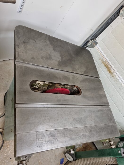 Metallbord med insänkt röd sågklinga i verkstadsmiljö, färdigslipat och polerat med slippapper och wd-40.