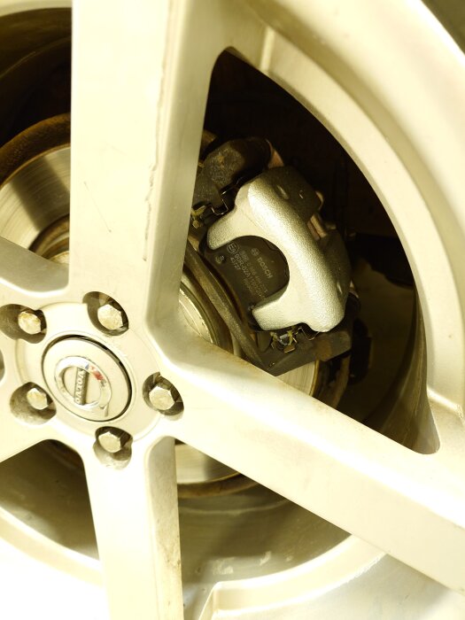 Närbild av bromsok på a-traktorhjul med synlig bromsskiva och fälg.