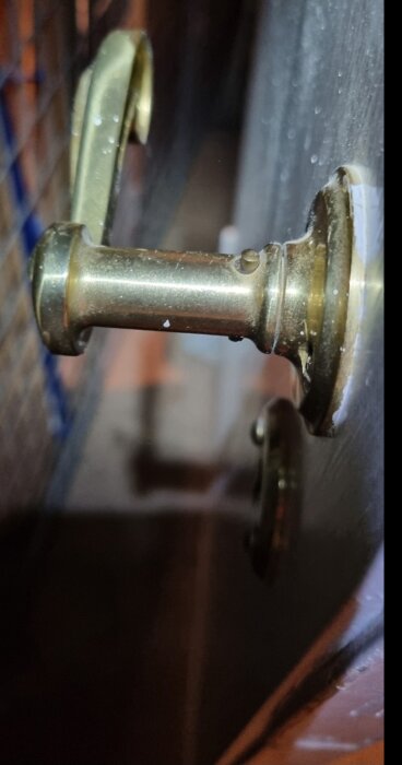 Gammalt dörrhandtag i metall på innerdörr från 1939, funkisstil.