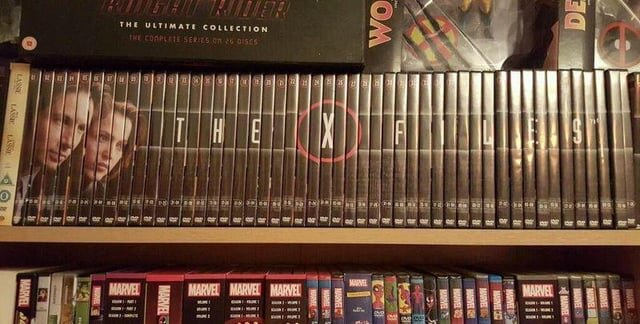 En hylla med DVD-boxar av TV-serien "The X-Files" och andra filmsamlingar, inklusive Marvel-serier, ordnade bredvid varandra.