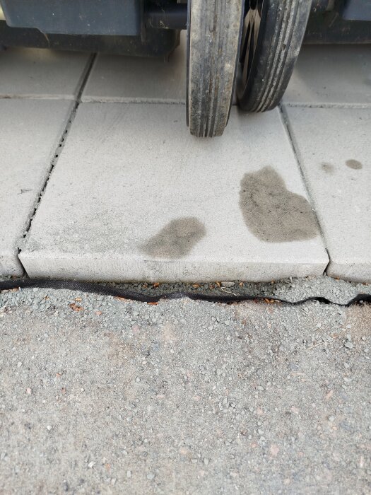 Plattor under soptunnorna med mellanrum till asfalten, plattorna är fem cm högre. Betongföreslag för fyllning.