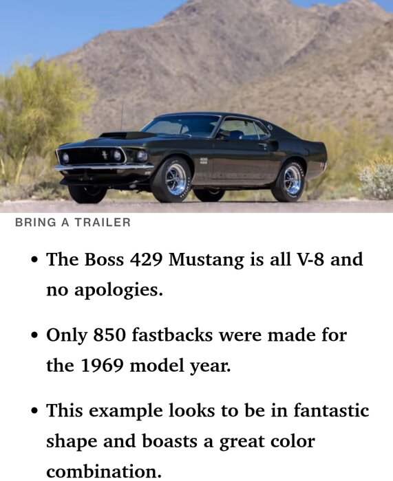 Svart 1969 Boss 429 Mustang står parkerad framför berg och kaktusar i öknen.