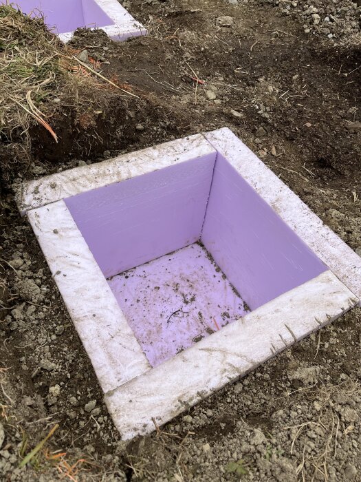Lila isoleringsmaterial i marken, möjligen XPS, förberedd för markjärn och betong.