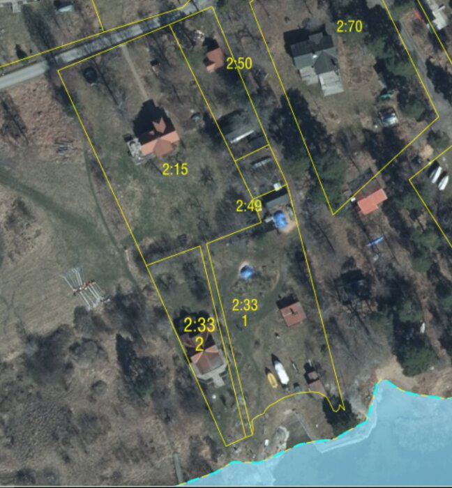 Flygfoto över fastigheter med markeringar 2:15, 2:33 och andra, där 2:33 består av två delar med emellanliggande remsa tillhörande 2:15.